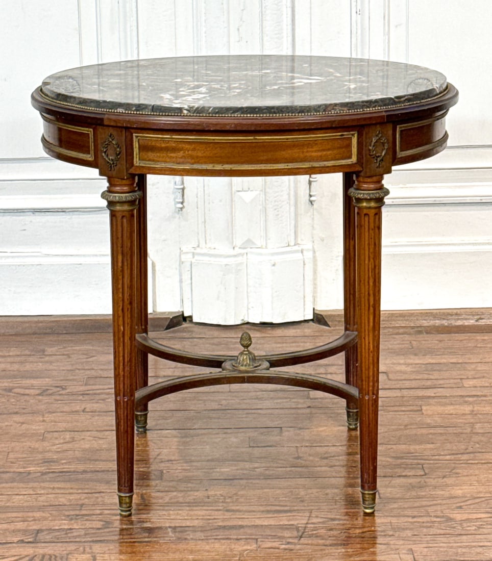 Louis XVI Style Marble Top Salon Table: Louis XVI Style Marble Top Salon Table, French, Mid 20th Century, Oval Grey Marble Top, Gilt Bronze Mounts On Mahogany Base With Stop Fluted Legs And Stretchers, 31 X 30 X 24 Inches, Chip To Marble
