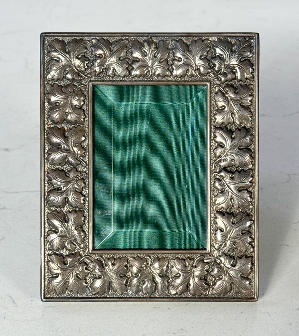 Bucellatti Sterling Silver Photo Frame: Bucellatti Sterling Silver Photo Frame, Italian, Circa 1995, Stamped Bucellatti Sterling Italy On Lower Edge, Repousse Oak Leaves, Beveled Glass, Green Leather Back With Prop And Silver Boss