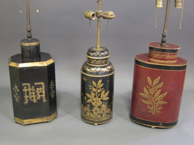 TOLEWARE LAMPS: A group of three decorative Toleware chinoisserie tea canister form table lamps with parcel gilt decoration. Two black, one red. The tallest measures