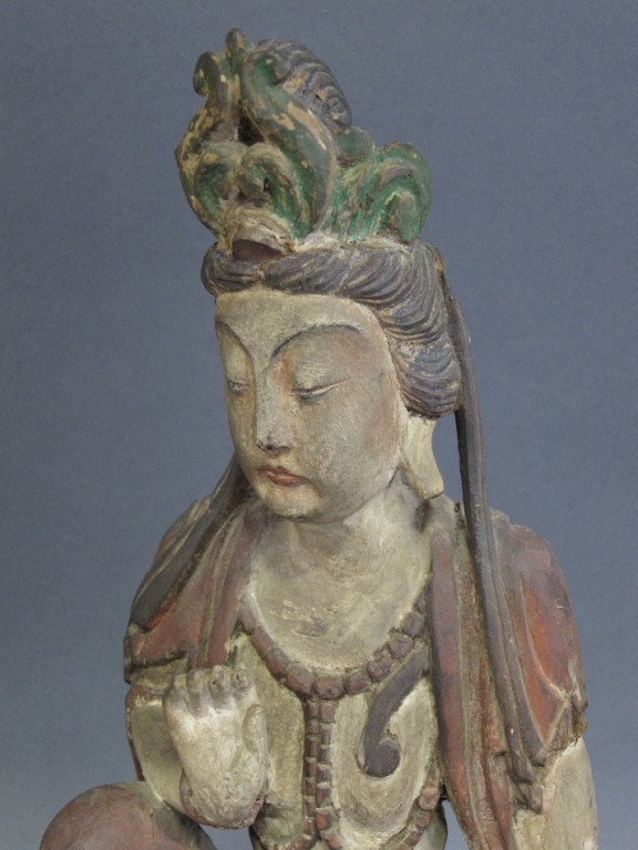 PAIR ORIENTAL FIGURES: Carved and polychromed wood with elaborate headdresses and robes, seated on rocks. Height 20.5". Mounted on ebonized bases.