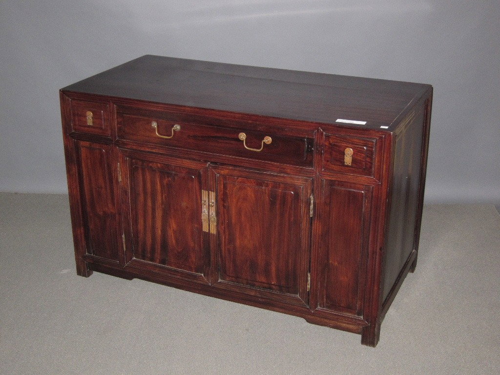 CHINESE CREDENZA: Rosewood storage cabinet fitted with one long drawer centered by two short drawers over double cabinet doors. 47 x 23.5 x 29.5."