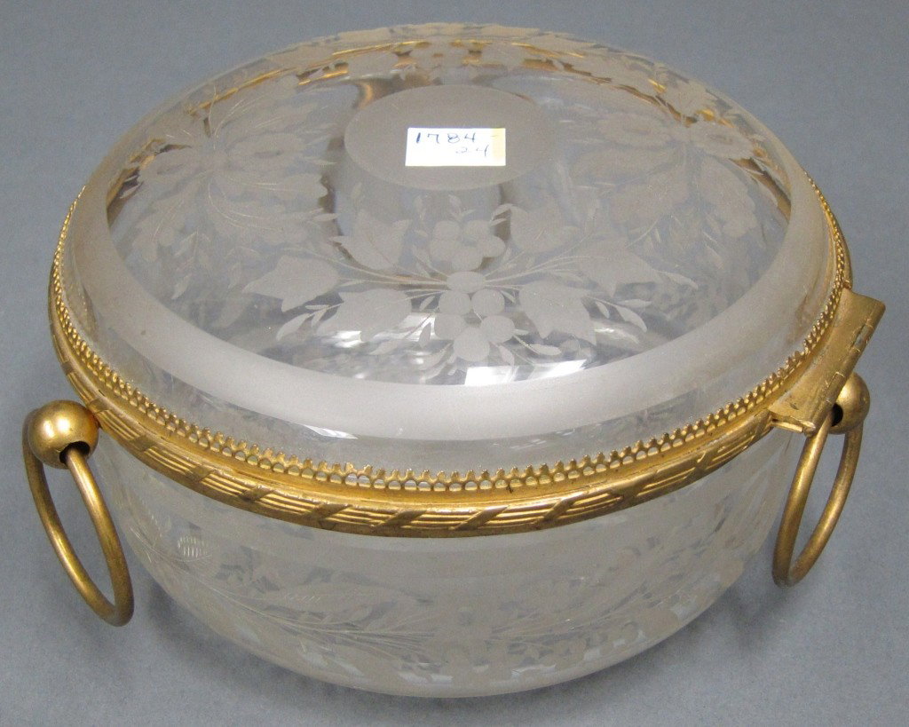 ANTIQUE ETCHED CRYSTAL BOX: Round with etched floral decoration top, sides, and bottom. Bronze banding and three loop handles. Diam. 6.75, H. 4.25."