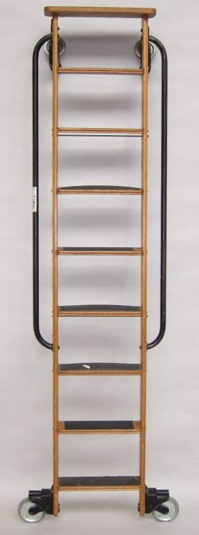 INDUSTRIAL LIBRARY LADDER: A solid oak constructed ladder with iron side handrails having 8 steps and wheel rollers. W. 16, H. 89.5."