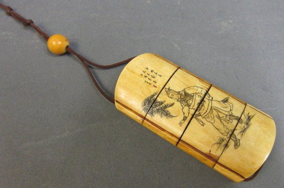 ANTIQUE ORIENTAL IVORY INRO: Comprised of four separating sections suspended by a string handle. Engraved on both sides. One side depicting a warrior, the other a bird in a flowering landscape. Both sides engraved with character 
