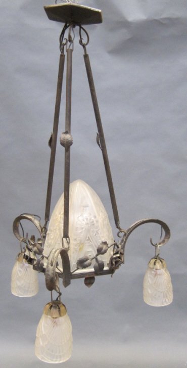 CHANDELIER: A 2nd quarter 20th C. French art deco wrought iron hanging four light fixture hand wrought in a rose vine motif. Fitted with a moulded center glass insert with three matching suspended globes. 21" in 