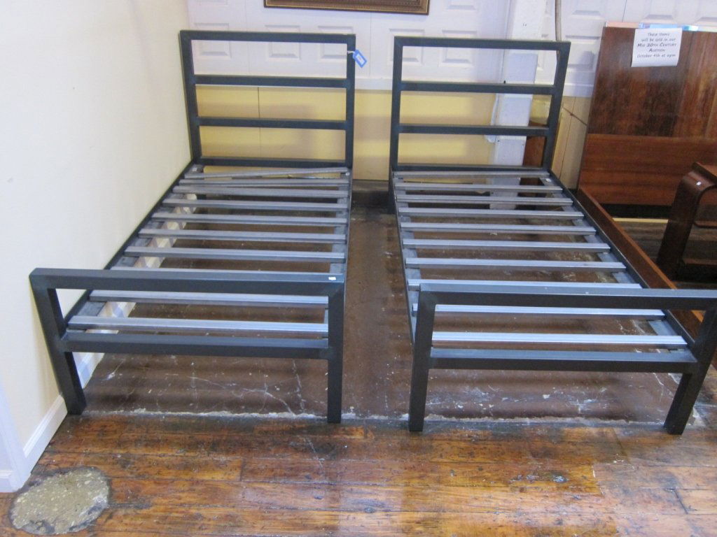 PAIR TWIN BEDSTEADS: a pair of contemporary steel twin size bedsteads having horizontal stilted headboards and fitted with chrome mattresses slats. 40"x 43.25" each Provenance: A group of fine property from a Larchmont Ne