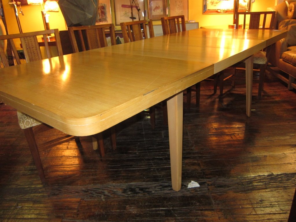 EDWARD WORMLY: A Mid-20th Century blonde wood dining table designed by Edward Wormley for "Drexel" for the "Precedent Collection" The rectangular top having rounded corners, raised on flared sqare tapering legs, fit