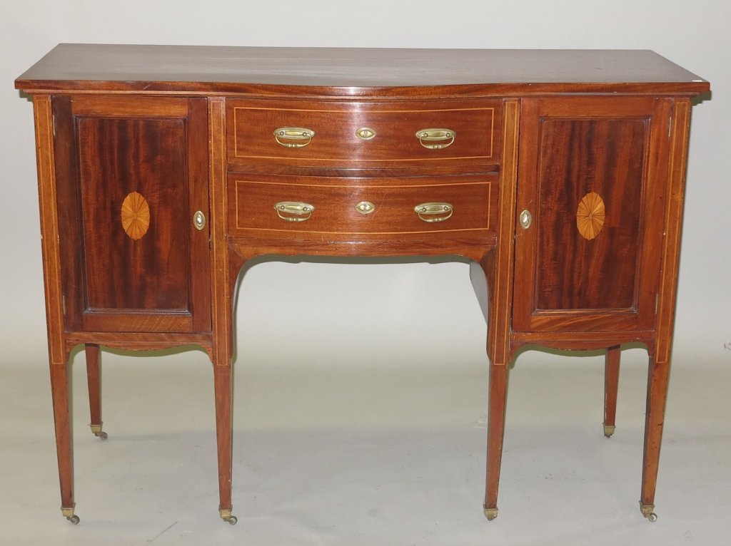 SIDEBOARD: A late 19th/early 20th c. English Edwardian satinwood marquetry and line inlaid mahogany bow front sideboard. The rectangular top above two long conforming drawers centered by single door cabinets to 