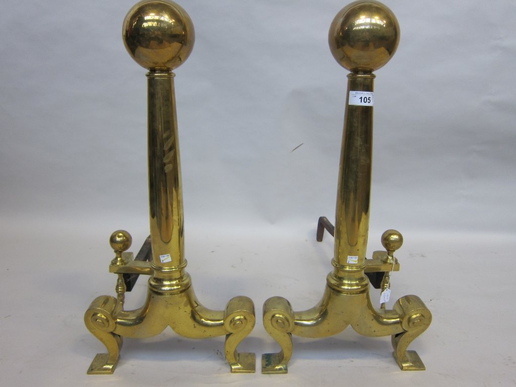PAIR OF ANDIRONS: A pair of early 19th Century continental brass andirons with cannon ball finials. Each raised on short scrolled legs, terminating on square pad feet. Measures; 30½" H Pre-Sale Estimate: $400/600