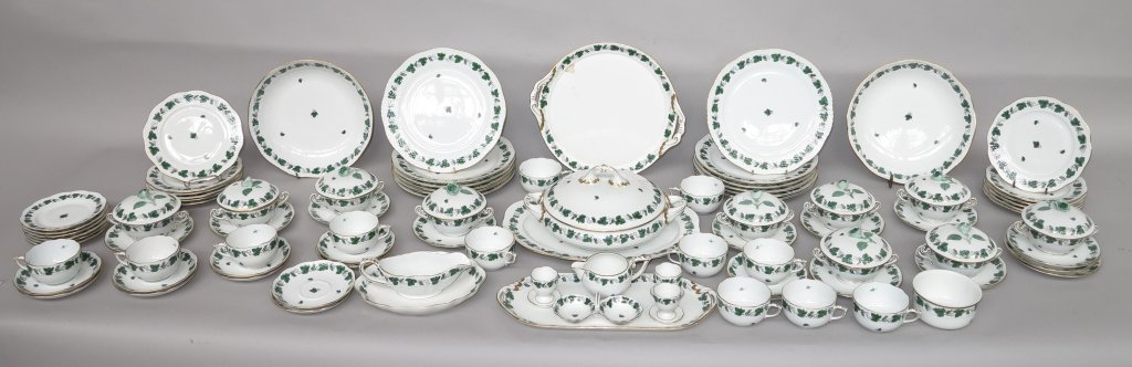 HEREND PORCELAIN DINNER SERVICE: Green grapevine pattern on white. Including: 12 dinner plates (Diam. 10"), 12 salad plates, 12 teacups and saucers, 10 lidded cream soups and saucers, a tureen, 2 serving bowls, 3 platters, sugar bowl