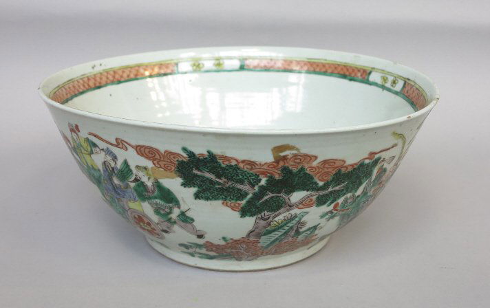 CHINESE PORCELAIN CENTER BOWL: Famille verte palette decorated with a procession of figures with animals and foo lions in a landscape. The interior with a seated figure. A red leaf mark to the base. Diam. 15.5, H. 6.75." Chip to th