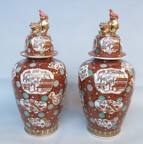 PAIR PALACE SIZE CHINESE PORCELAIN LIDDED JARS: Iron rust ground with panels decorated with trees, houses, peacocks and symbols. The gilt scrolled ground with geometric circle motifs. The lids with large foo lion finials. H. 34."