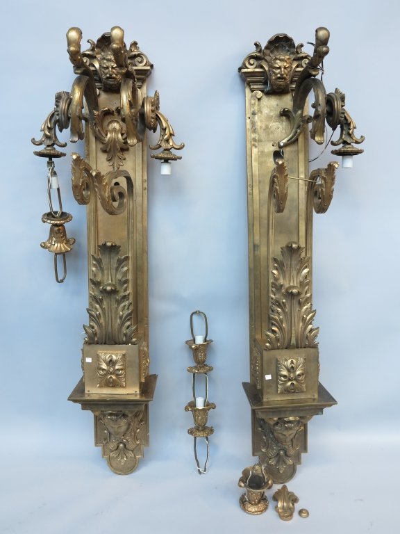 PAIR LOBBY SCONCES: A pair antique massive and elaborate French neoclassical style bronze lobby wall sconces. the mask adorned crests above 3 downward scrolled acanthus leaf lights over a figural head bracket form base. 