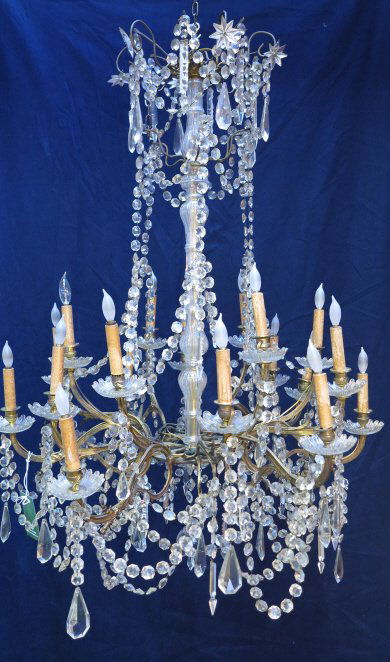 CHANDELIER: An antique massive and elaborate French gilt bronze framed 18 light chandelier heavily decorated with cut crystal beaded gadrooned swags and tear drop pendants, the whole capped with a canopy crown mo