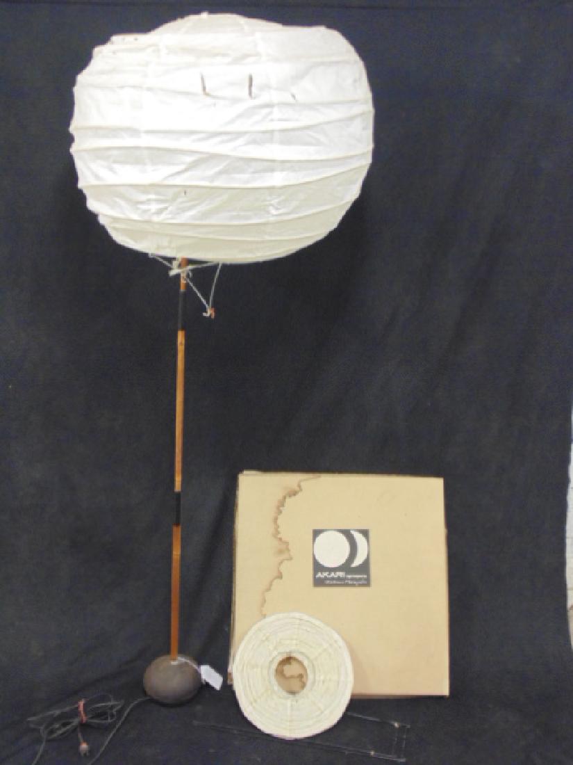 Akari light sculpture lot by Isamu Noguchi: Akari light sculpture by Isamu Noguchi, shade on bamboo, shade ripped, comes with small lamp in original box Please refer to images for general condition issues, all items are sold in as is, as found 