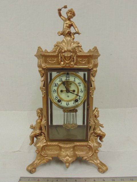 Crystal regulator, Ansonia, with cherubs on case: Crystal clock, regulator, Ansonia, with cherubs on case, case is gold painted, case appears to be brass & white metal, pendulum needs repair, case is 19.5\" tall,
