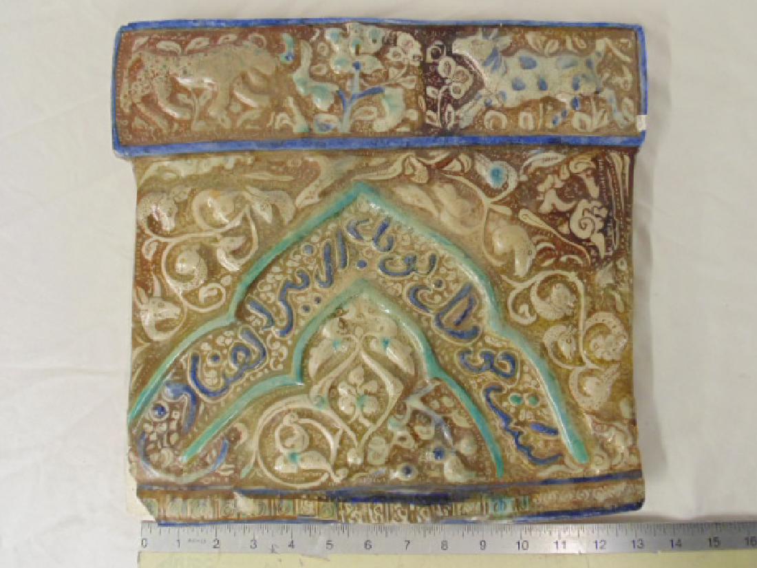 Kashan Calligraphic Luster Tile, Persian, 13th / 14th: Kashan Calligraphic Luster Tile, Persian, 13th / 14th Century, with moulded relief design of a frieze of animals at the top, and part of an arch containing script in the main section. Provenance: Isla