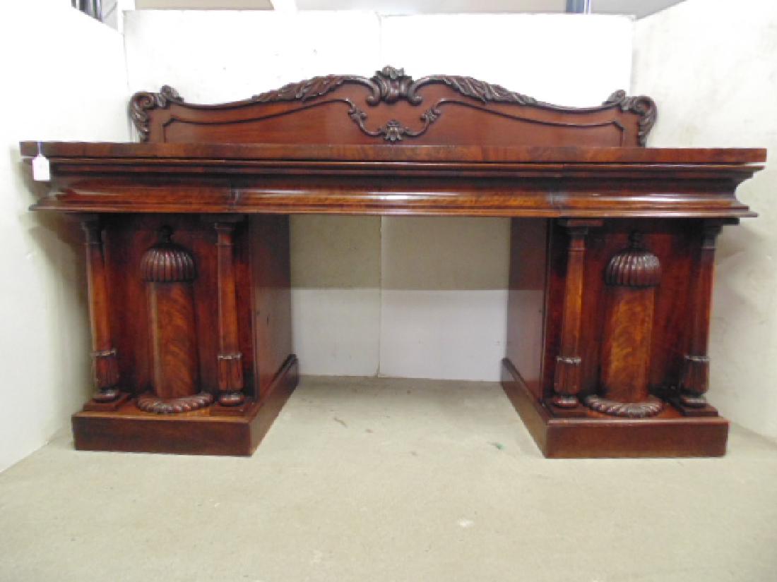 Mahogany double pedestal side board, fine example of: Mahogany double pedestal side board, fine example of Empire furniture featuring double column pedestal bases with center carved column, and 3 drawer top with ornate carved back splash, side board is 8