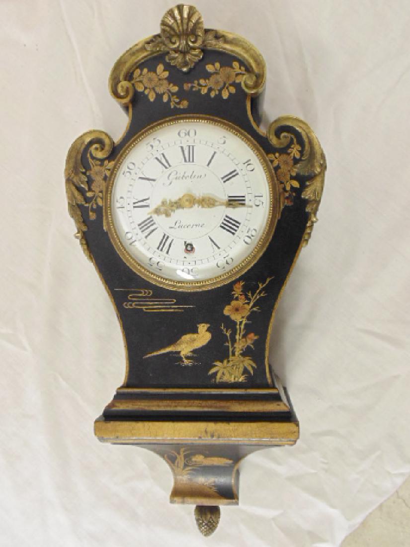 Gubelin, Lucerne wall clock, paint decorated case,: Gubelin, black lacquer Lucerne wall clock, paint decorated case, bronze trim.Clock was purchased by the consignor from Gubelin in Switzerland, having gold leafed oriental & bird design.Acorn brass fin