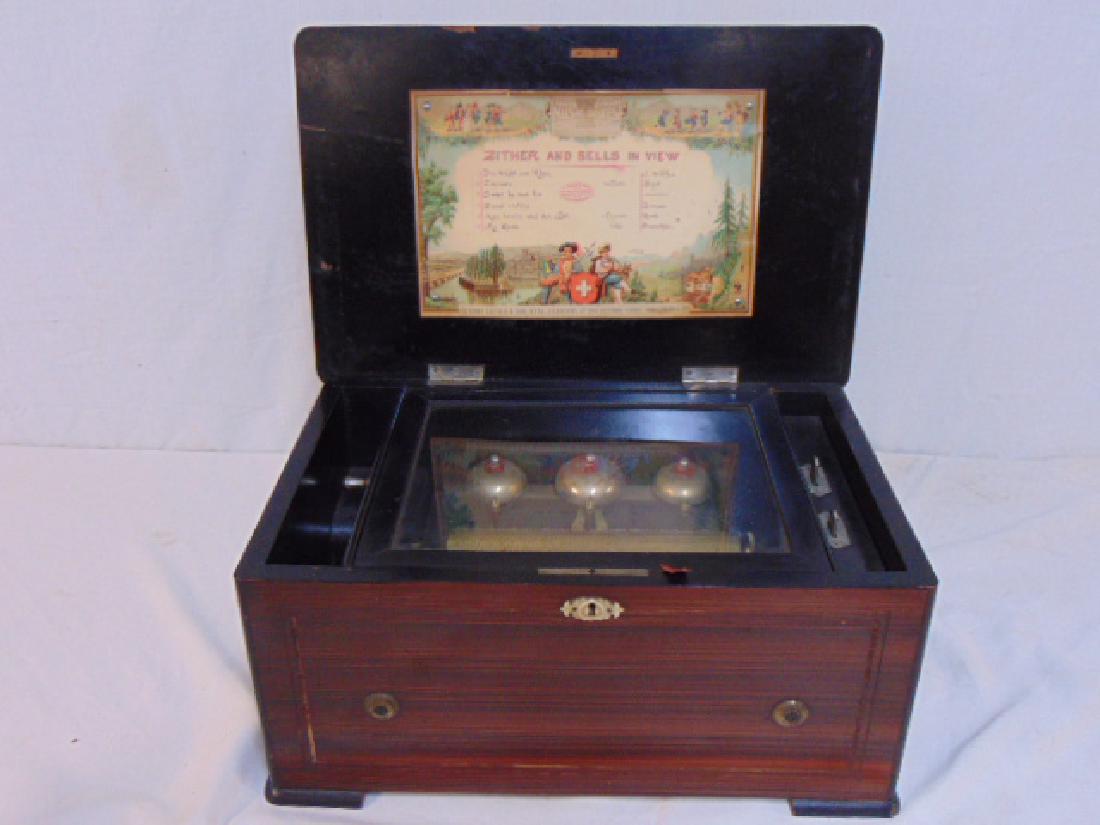 Inlaid music box, zither and bells in view, by music: Inlaid music box, zither and bells in view, by music box plays 6 tunes, working condition, stop button is not functioning, all teeth are there. Cabinet size is 17.25" by 11.25", height is 8.5". Some i