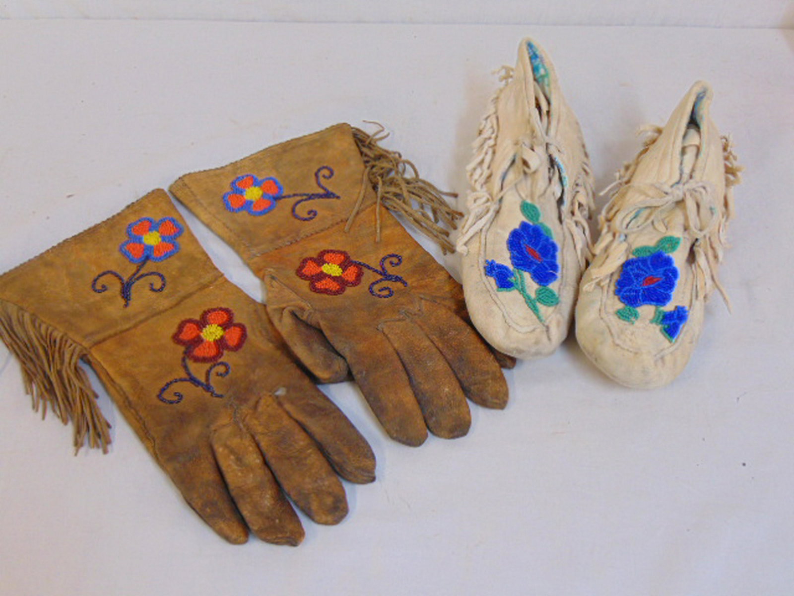 Beaded Native Indian gloves & moccasins, both gloves &: Beaded Native Indian gloves & moccasins, both gloves & moccasins have floral decorated beadwork, worn, stained.