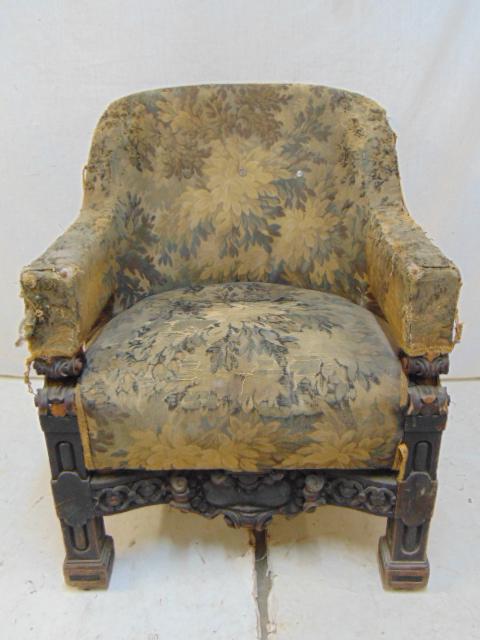 Upholstered arm chair, tapestry like upholstery, carved: Upholstered arm chair, tapestry like upholstery, carved cross stretcher in front, black painted frame. Possibly architect designed