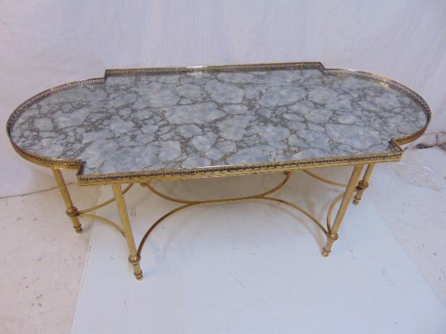 Mirrored top brass base coffee table, 6 spiral legs,: Mirrored top brass base coffee table, 6 spiral legs, stretcher base, table is 43.25" by 20", height is 17.75", mirrored top has faux marble effect. Notice: Please note that our auctions will continue 