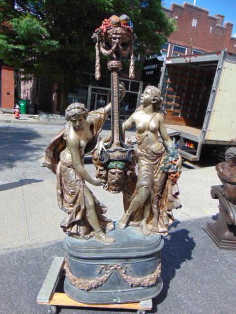 Zinc figural fountain, 2 semi nude women & Bacchus: Zinc figural fountain, 2 semi nude women with head of Bacchus, paint & gilt detail, fountain is 72" tall, base is 29" by 14".Unsure about the weight, guess is 300 pounds or so, water comes out of Bacc