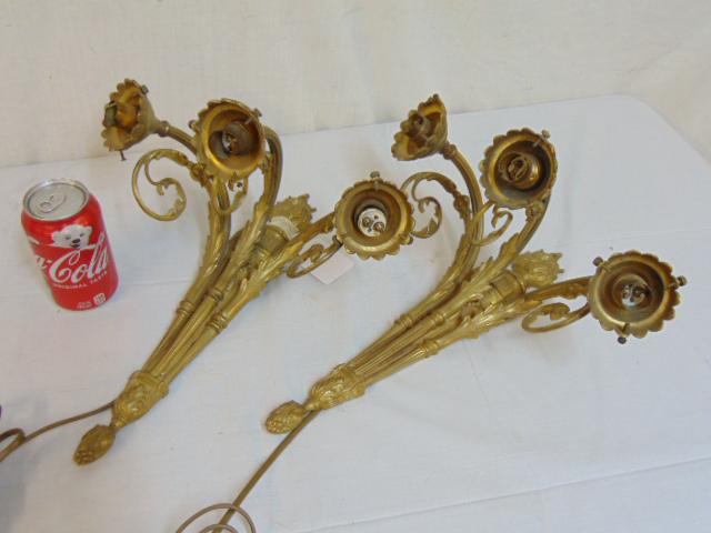Pair gilt bronze wall sconces, torch shaped center with: Pair gilt bronze wall sconces, torch shaped center with three arms, one socket broken, sconces are 15.5" long.
