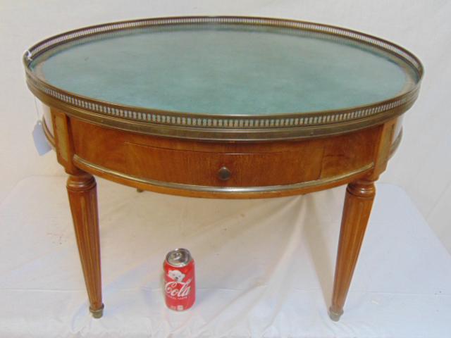 Round leather top coffee table with brass gallery, pull: Round leather top coffee table with brass gallery, pull out shelves & drawer, top is 29.75" in diameter, height is 19 5/8"