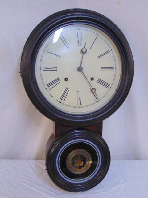 Ingraham & Co. 8 day wall clock, rosewood case, with: Ingraham & Co. 8 day wall clock, rosewood case, with reverse painted Eglomise bottom door, clock is 21.5" tall, width (top) is 13.25", Note, this is the Ionic model, has been re- veneered, and the Ion