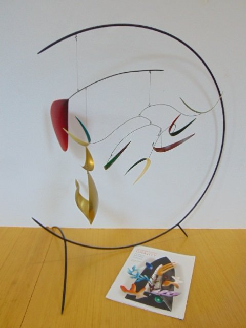 Standing Mobile by Mark Davis, in brass and aluminum: Standing Mobile by Mark Davis, in brass and aluminum with steel wires, oil and acrylic colors, approx 34" wide 29" tall.Two very small chips on the edge of the red part (see images)