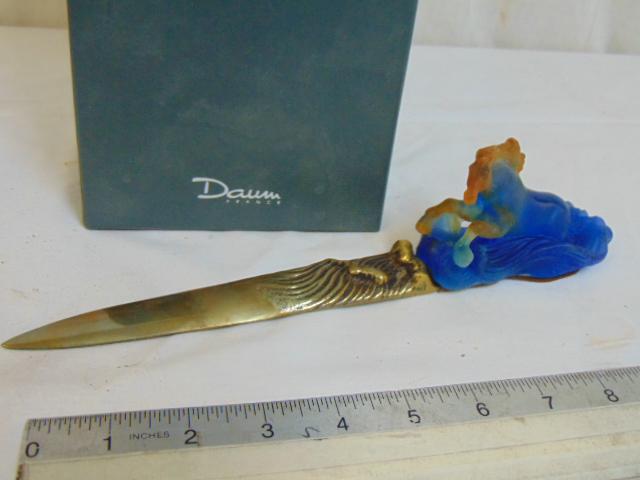 Daum art glass & brass letter opener, brass blade with: Daum art glass & brass letter opener, brass blade with art glass handle in the shape of a galloping horse, in blue glass, in original box, good condition.