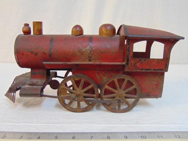 Tole toy locomotive, in red paint, some rust, loss of: Tole toy locomotive, in red paint, some rust, loss of paint, train is 14" long, height is 6.5"