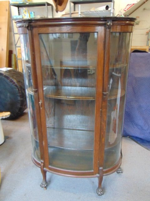 Curved oak china cabinet with wood shelves, claw feet,: Curved oak china cabinet with wood shelves, claw feet, cabinet is 40.75" wide, 16.25" deep, height is 64", one front leg is loose