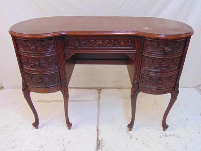 Carved mahogany desk, kidney style, triple drawer sides: Carved mahogany desk, kidney style, triple drawer sides with center drawer, desk is 44" by 19", height is 30", one pull missing.