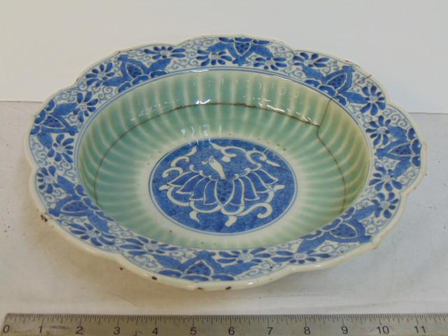Asian Japanese porcelain bowl with remarkable staple: Asian Japanese porcelain bowl with remarkable staple restoration, bird like decoration in center, decorative blue & white border, bowl is 11.5" in diameter, height is 3.25", signed.