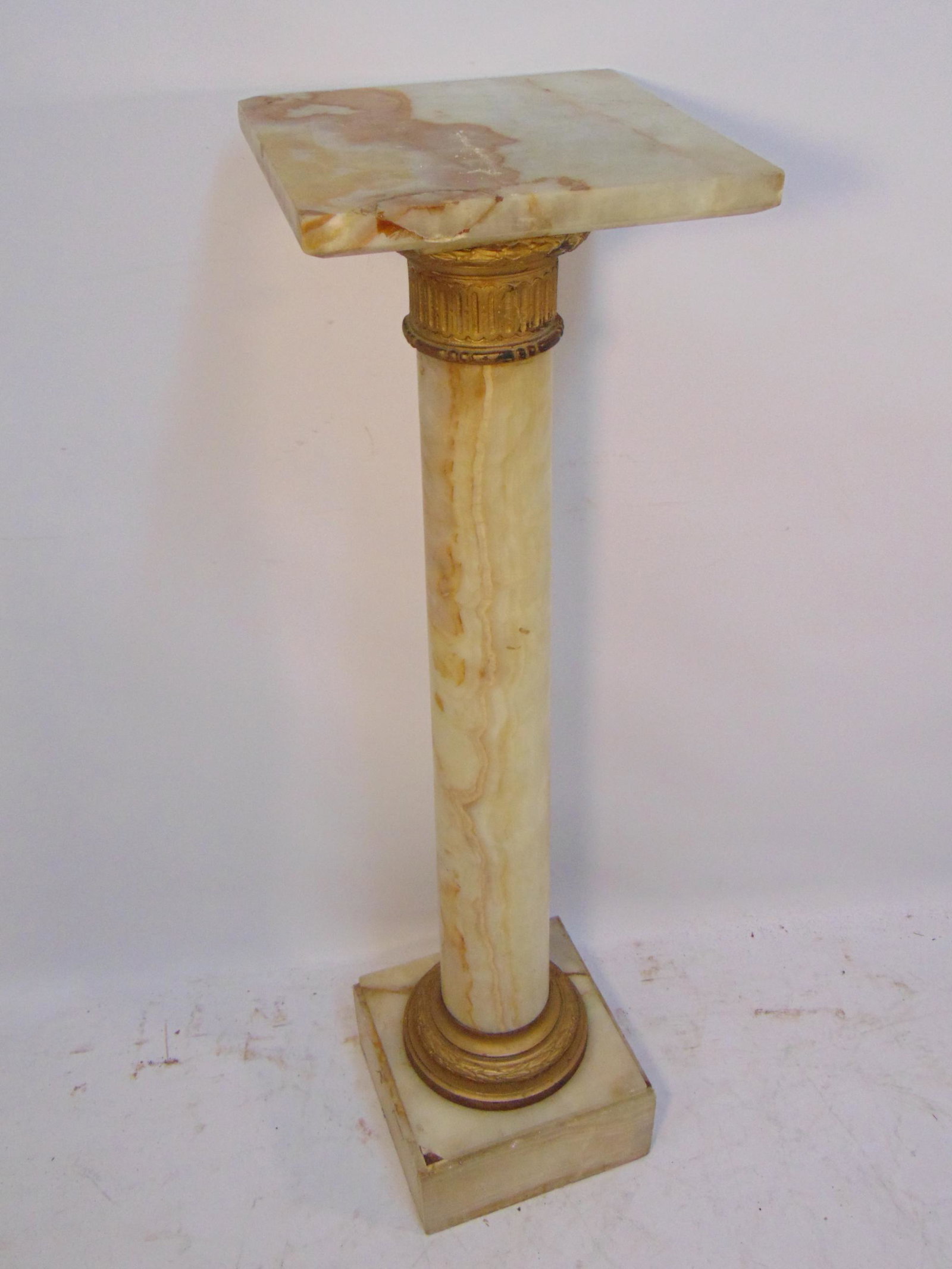 Onyx pedestal with bronze mounds, some panels are: Onyx pedestal with bronze mounds, some panels are cracked (base), chips, as is condition, pedestal is 39.5" tall.