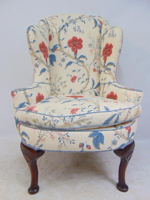 Floral upholstered wingback armchair, with carved legs,: Floral upholstered wingback armchair, with carved legs, fan design, chair is 33" by 23", height is 49", seat height is 23"