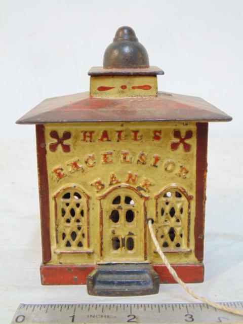 J.E. Stevens cast iron bank, in original paint, iron in good condition, "Hall's Excelsior Bank",: J.E. Stevens cast iron bank, in original paint, iron in good condition, "Hall's Excelsior Bank", teller figure possibly replaced, bank is 4.75"