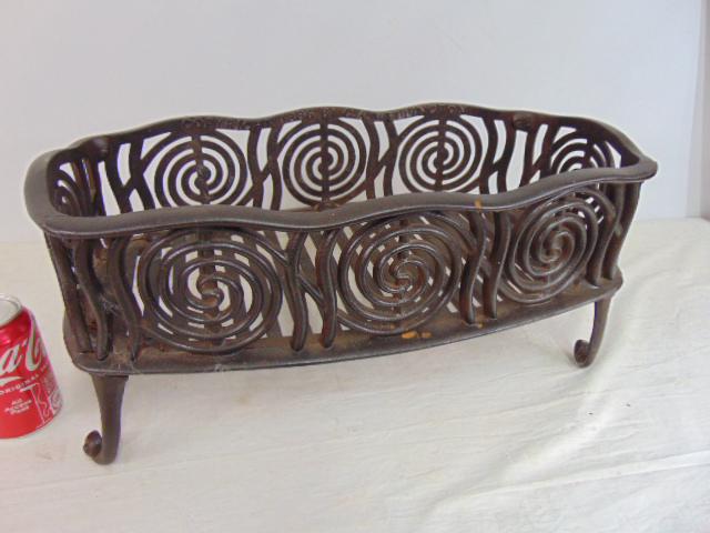 Cast iron fire grate, copyright 1886 by C.A. Wellington, with decorative spiral designs, one leg (1 of 5)