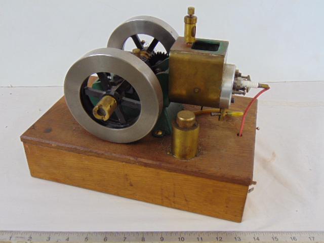 Engine with large flywheels, piston drive with spark plug, various parts in base, on oak lift up (1 of 7)