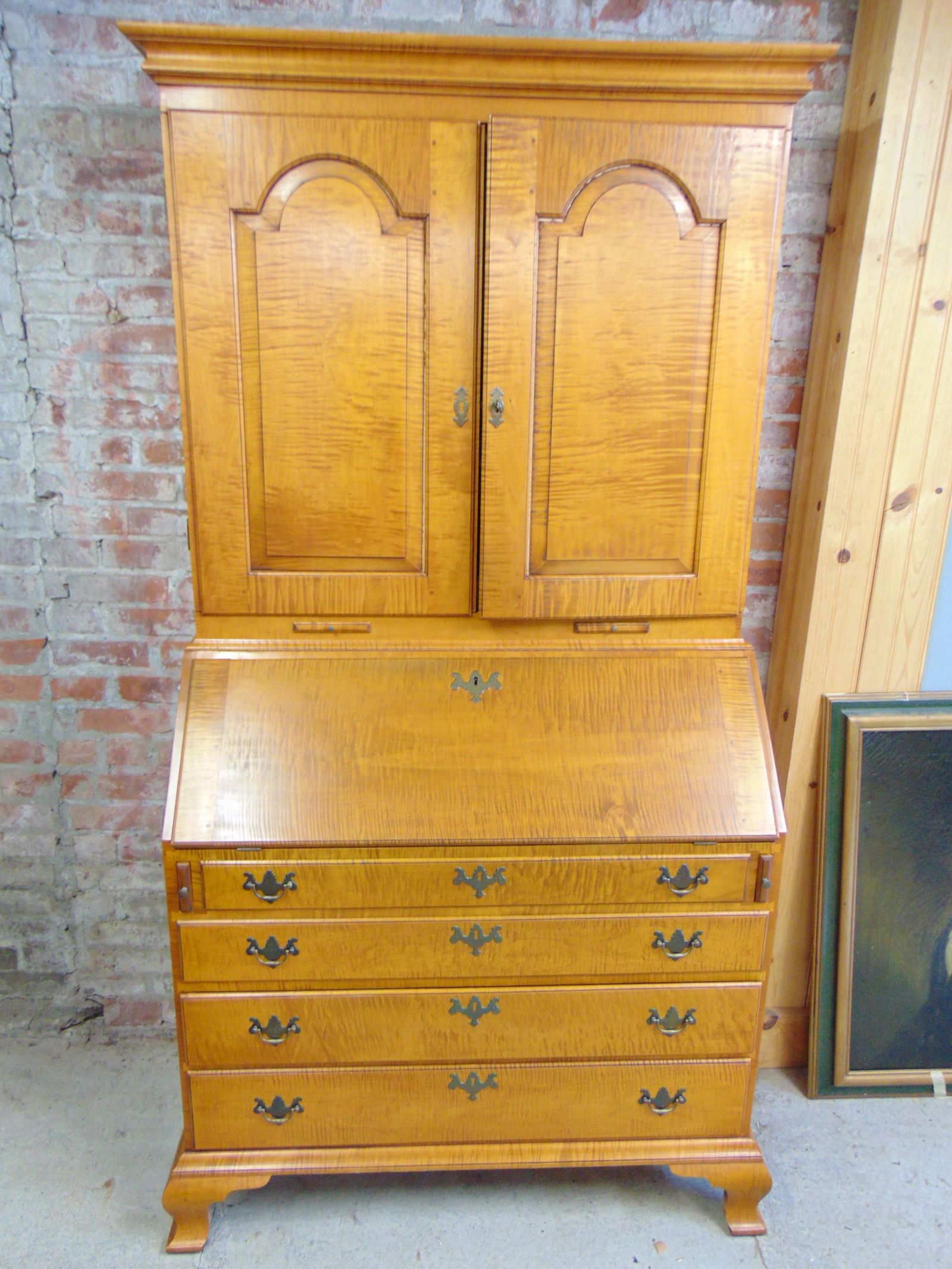 Eldred Wheeler tiger maple secretary desk, 4 drawer base, two door top, label in top drawer,: Eldred Wheeler tiger maple secretary desk, 4 drawer base, two door top, label in top drawer, Chippendale hardware, desk area & top fitted with small drawers, several secret drawers, desk is 42" wide,