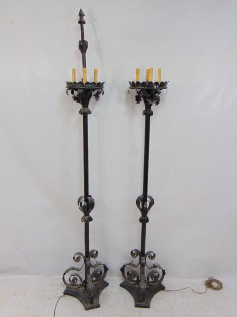 Pair iron lanterns, torchier in black paint, 4 socket top, floral decorated, height is 64.5", one: Pair iron lanterns, torchier in black paint, 4 socket top, floral decorated, height is 64.5", one has broken center finial, other is missing.