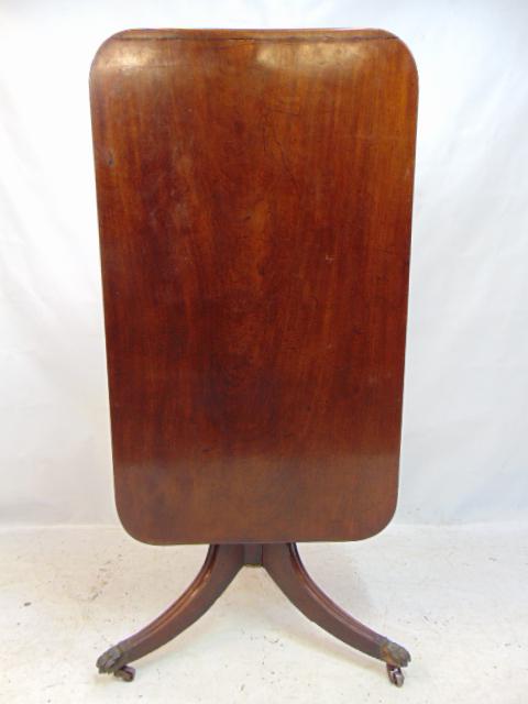 Tilt top breakfast table, solid mahogany top on Duncan Phyfe style base, top is 25" by 42", height: Tilt top breakfast table, solid mahogany top on Duncan Phyfe style base, top is 25" by 42", height table when set up is 28.25", old repairs to base, hinge block is cracked