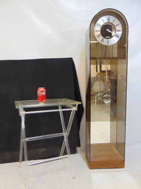 Lucite folding stand & Howard Miller plastic cases tall clock, clock as is, no weights, hand: Lucite folding stand & Howard Miller plastic cases tall clock, clock as is, no weights, hand missing, in smokey brown plastic, height clock is 55", height folding table is 25"