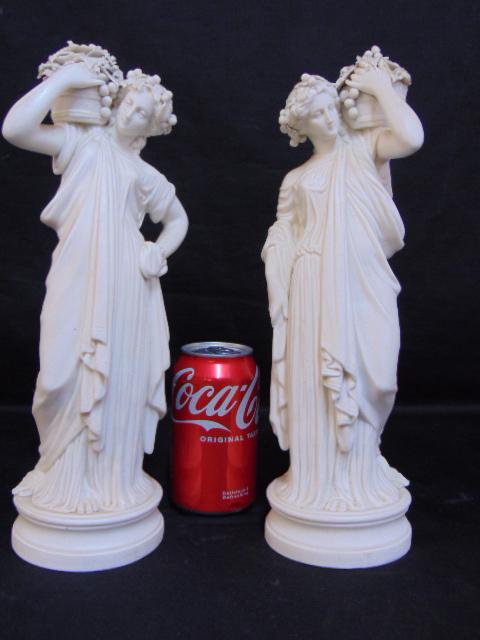 Pair Parian figures, woman with grape baskets on shoulder, height is 13", some chips, loss to the: Pair Parian figures, woman with grape baskets on shoulder, height is 13", some chips, loss to the basket area.