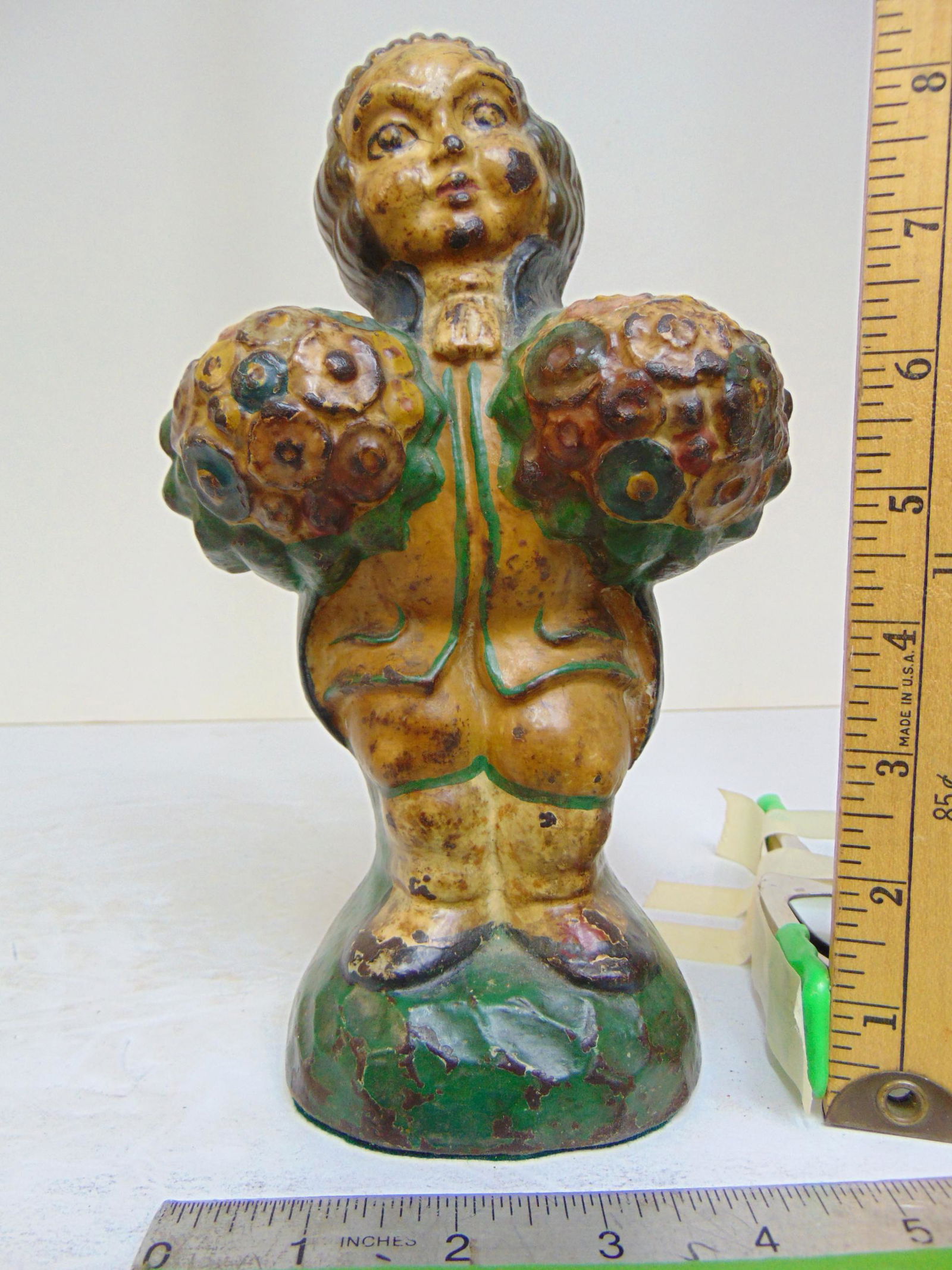Cast iron doorstop, figure carrying bunches of flowers, heavy, # 821 on back, height is 9 1/8": Cast iron doorstop, figure carrying bunches of flowers, heavy, # 821 on back, height is 9 1/8"