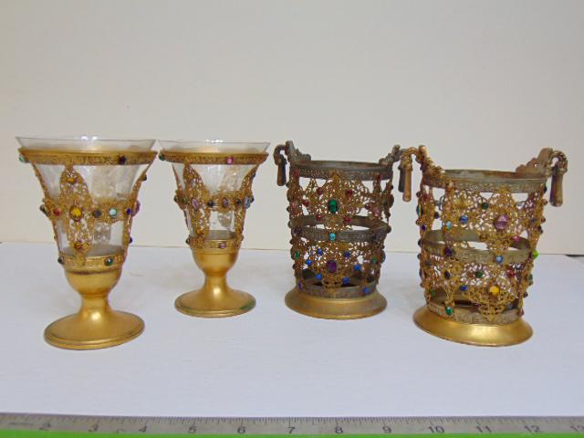 2 pair Apollo jeweled gold toned cups with glass inserts (one pair has inserts), decorated with: 2 pair Apollo jeweled gold toned cups with glass inserts (one pair has inserts), decorated with various multi colored faceted glass jewels, height is 6", glass inserts are etched, and one is chipped.