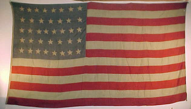 38 star United States flag: Great looking vintage 38 star flag, wear is evident, it was likely displayed vertically as two small weights are located on the upper & lower right, the flag is 97" wide and 171" long. The stars are i